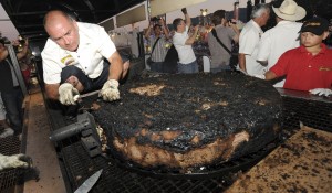 Brett Enright works on a Guinness World Records breaking World's Largest Commercially Available Hamburger at the Alameda County Fair in Pleasanton, Calif., in 2011. The burger weighed 777 pounds. (AP Photo / The Contra Costa Times, Doug Duran)